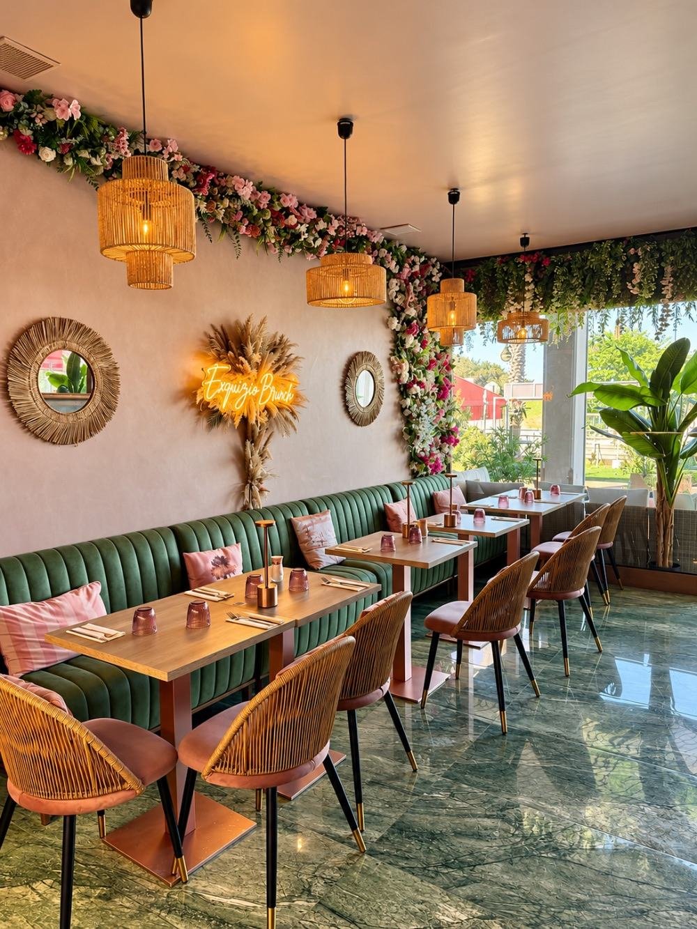La salle d'Exquizio : néon Exquizio Brunch, banquettes en velours vert, suspensions en rotin et sol en marbre vert